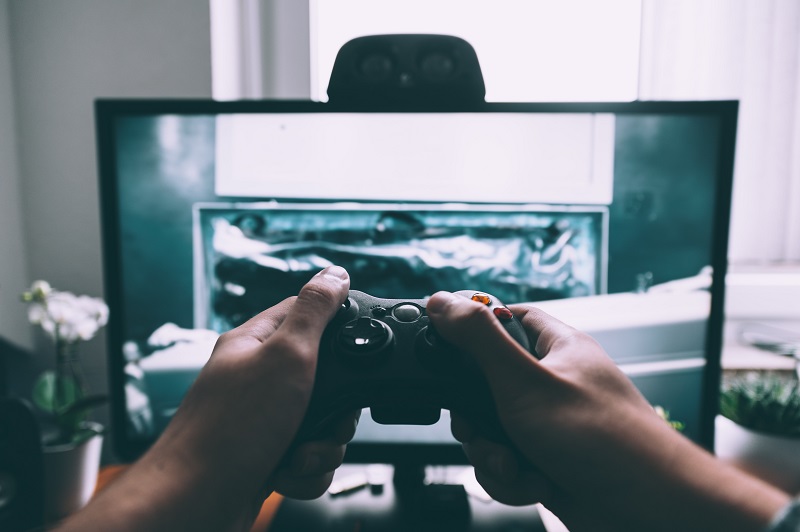 A teen playing on a gaming console.